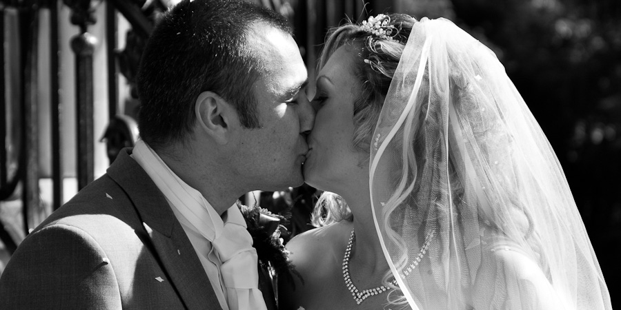 Bride and groom celebrate with a kiss as they pose for their wedding photography in Manchester