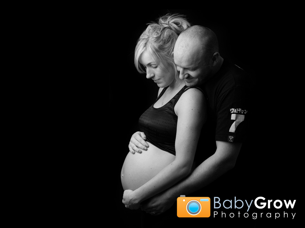Expectant Mum and Dad looking down at baby bump