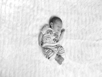 Newborn baby boy asleep in the middle of a blanket